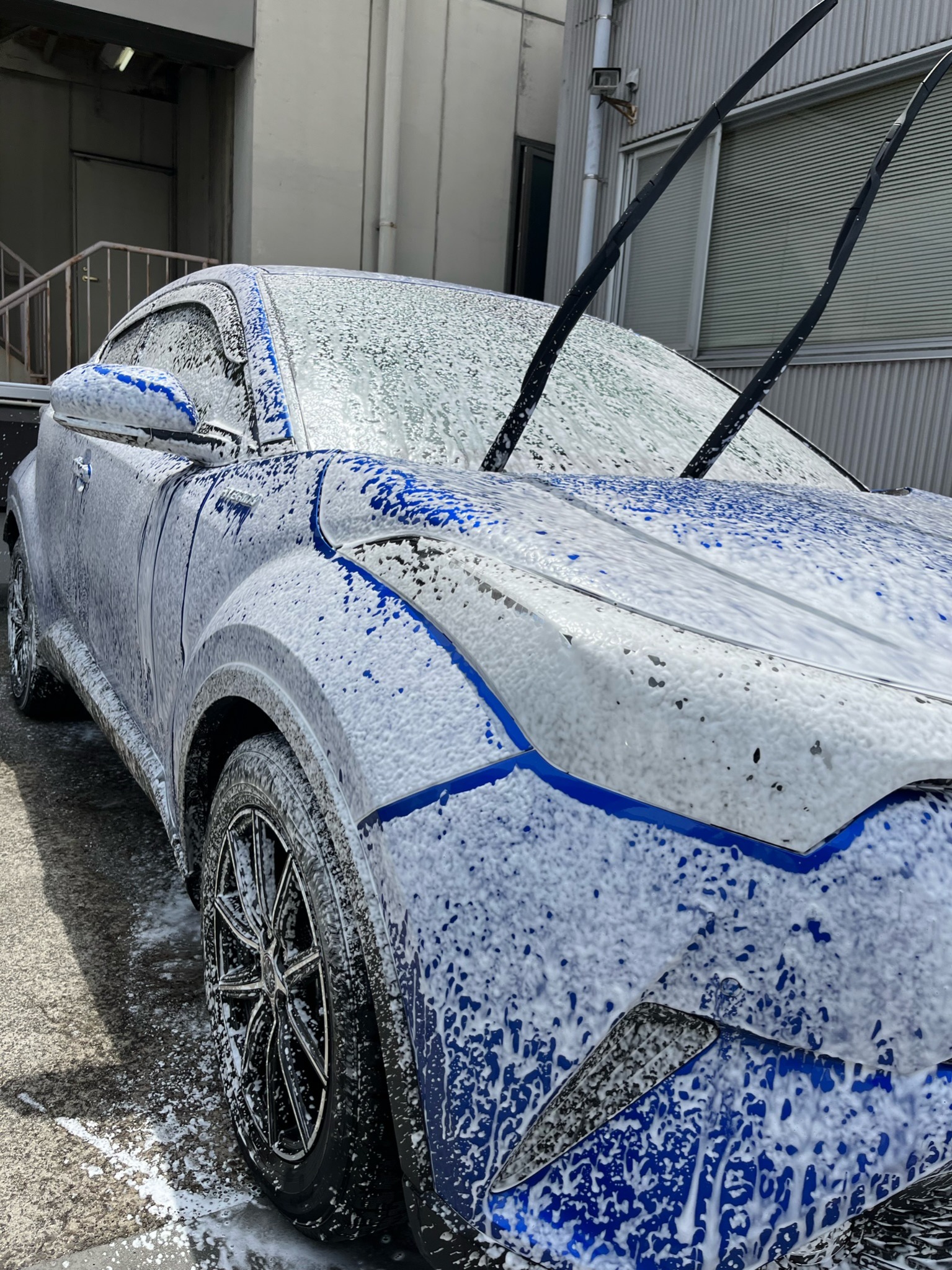 泡洗車中の車両。ボディ全体がきめ細かい泡で覆われている